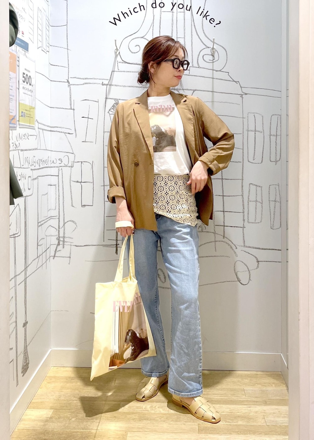 ブルー系のデニムパンツ、ベージュ系のサンダル、イエロー系のテーラードジャケットを着用したレディースの春コーディネートの2枚目の写真