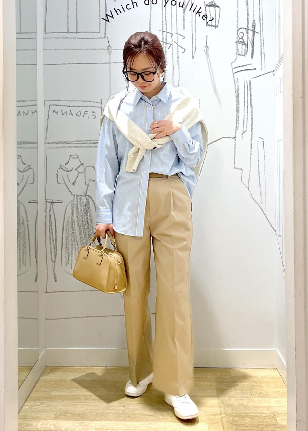 ベージュ系のボストンバッグ、ホワイト系のスウェット、ベージュ系のチノパンツを着用したレディースの春コーディネートの2枚目の写真