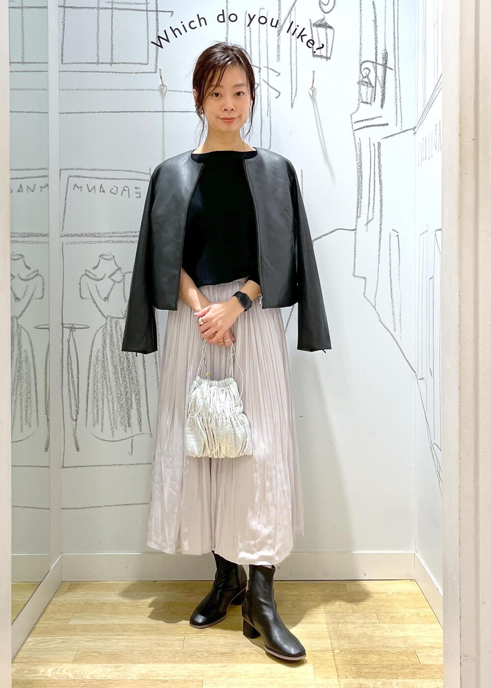 ブラック系のノーカラージャケット、ブラック系のブーツ、シルバー系のショルダーバッグを着用したレディースの冬コーディネートの6枚目の写真