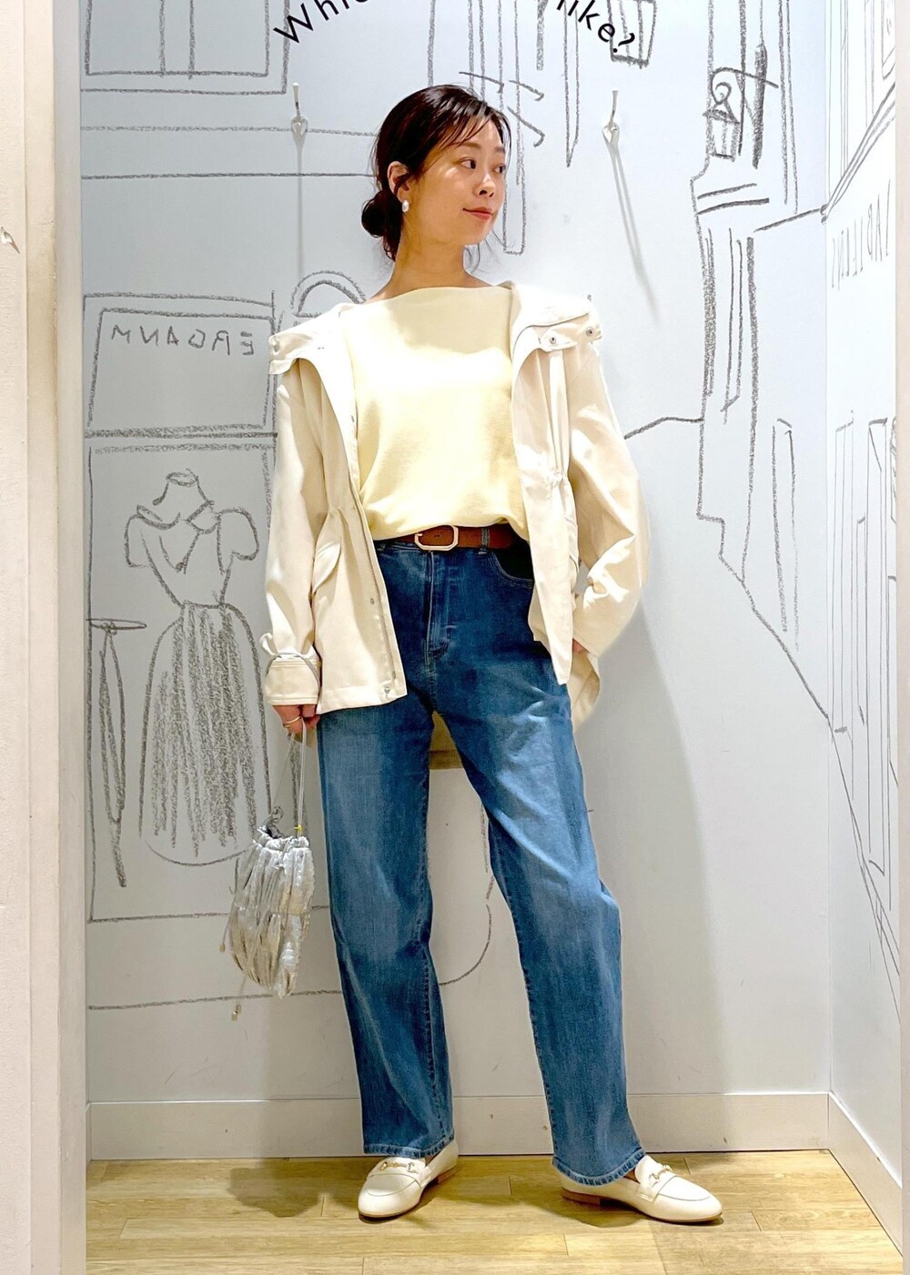 ホワイト系のマウンテンパーカー、シルバー系のショルダーバッグ、ブルー系のデニムパンツを着用したレディースの冬コーディネートの6枚目の写真