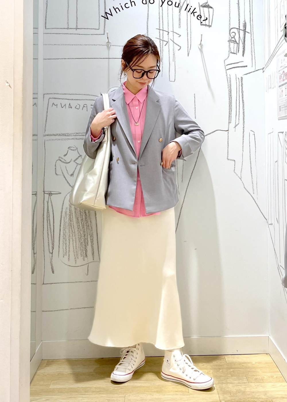 シルバー系のトートバッグ、グレー系のベスト、ホワイト系のスカートを着用したレディースの春コーディネートの4枚目の写真