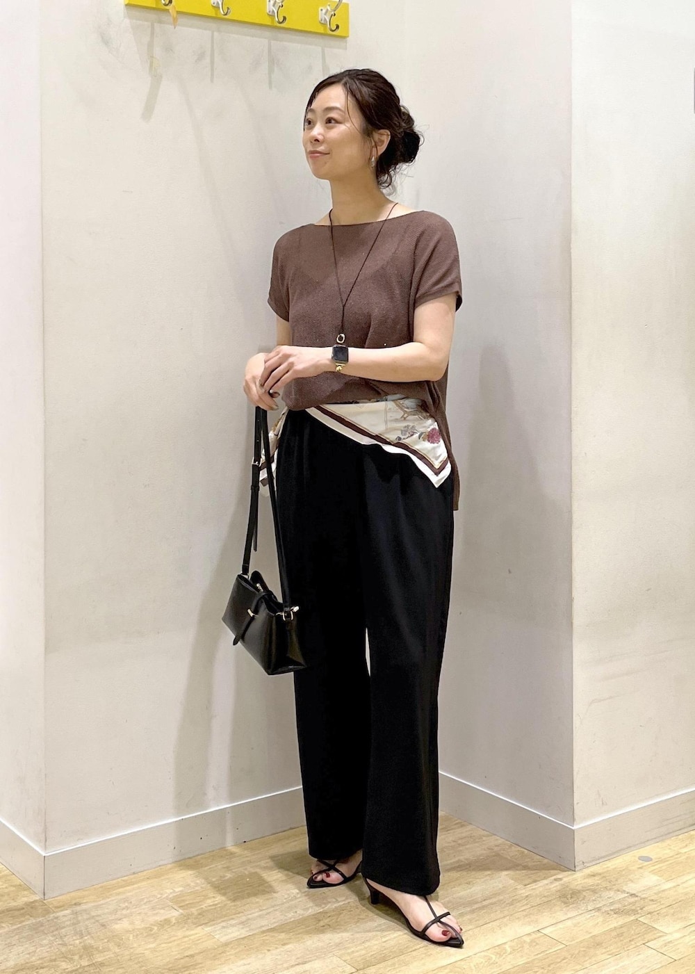ブラック系のショルダーバッグ、ブラック系のその他パンツ、イエロー系のニット/セーターを着用したレディースの夏コーディネートの3枚目の写真