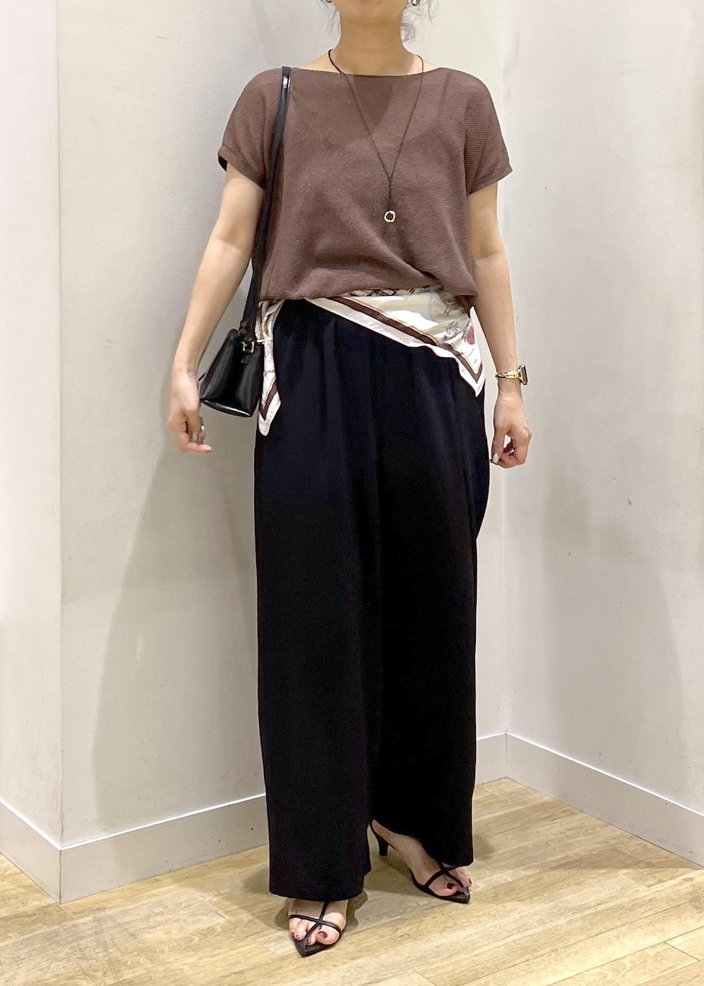 ブラック系のショルダーバッグ、ブラック系のその他パンツ、イエロー系のニット/セーターを着用したレディースの夏コーディネートの6枚目の写真