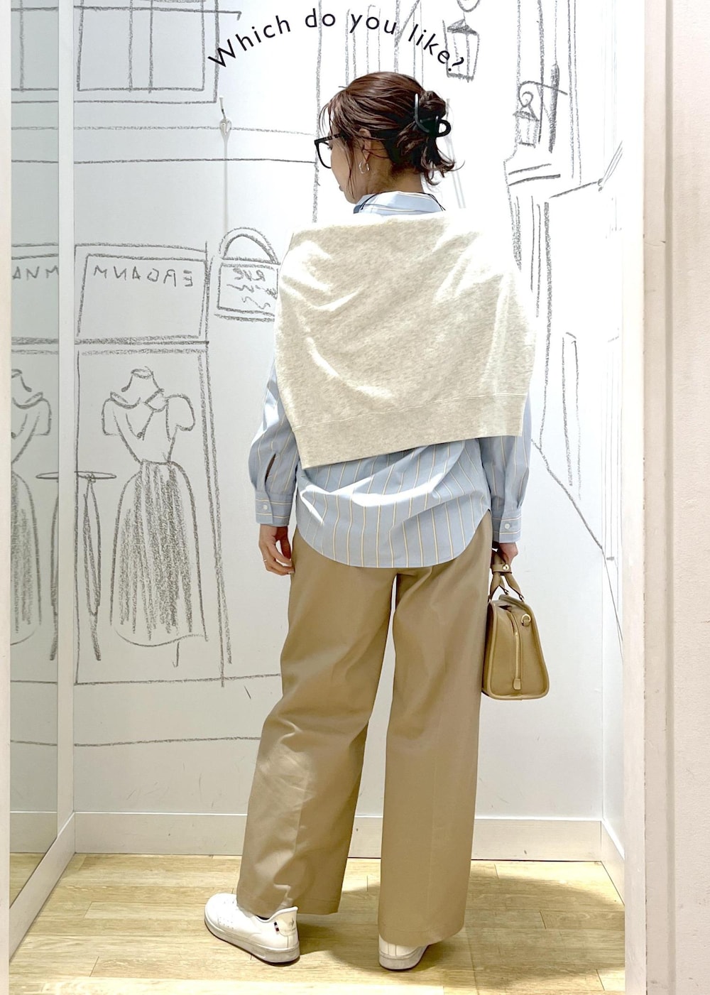 ベージュ系のボストンバッグ、ホワイト系のスウェット、ベージュ系のチノパンツを着用したレディースの春コーディネートの5枚目の写真