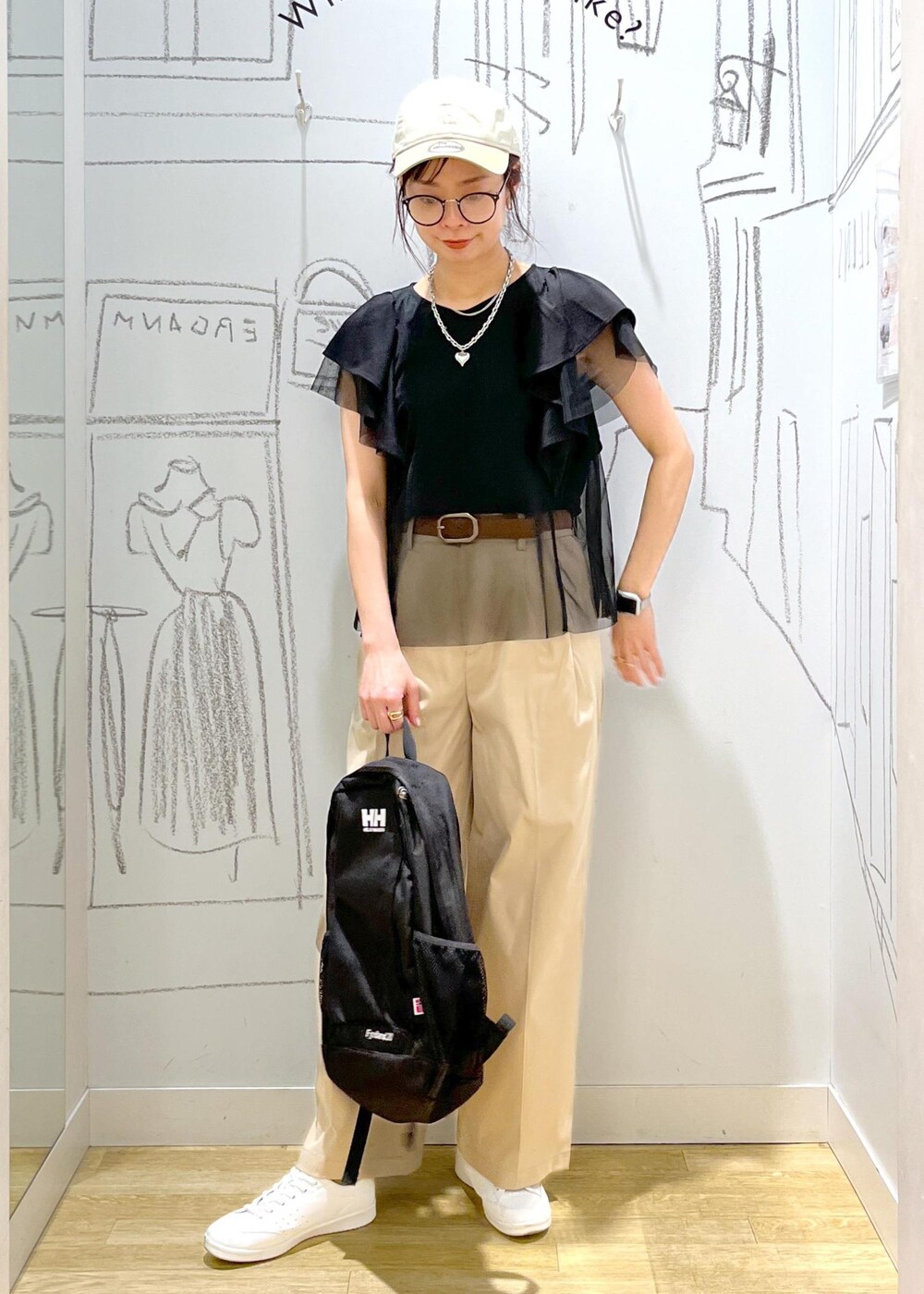 ベージュ系のチノパンツ、ブラック系のTシャツ/カットソー、ホワイト系のスニーカーを着用したレディースの春コーディネートの2枚目の写真