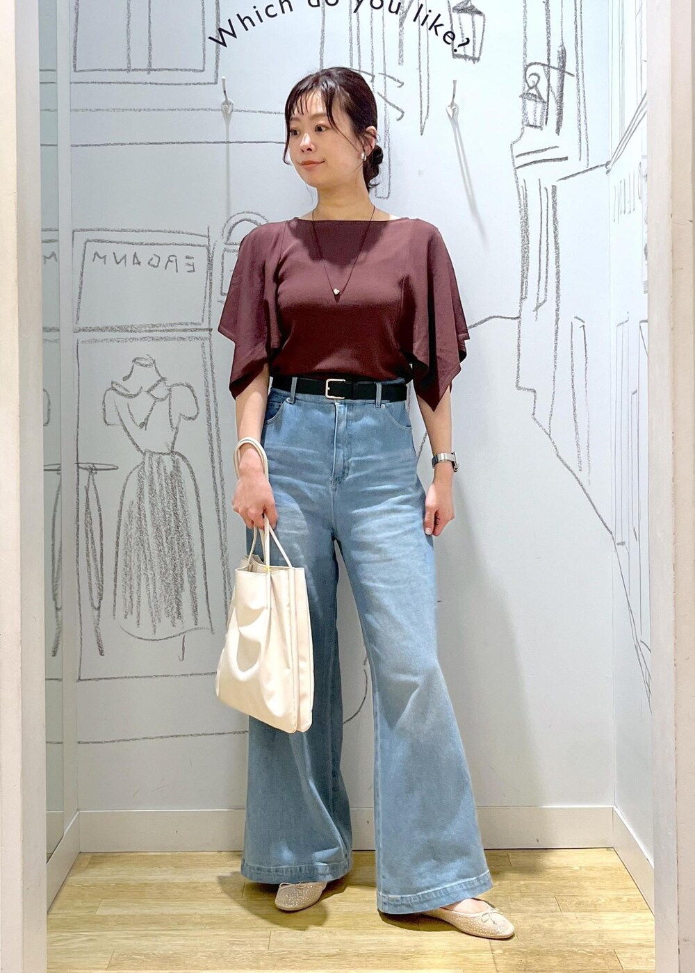 ホワイト系のトートバッグ、ブルー系のデニムパンツ、ブラウン系のニット/セーターを着用したレディースの春コーディネートの2枚目の写真