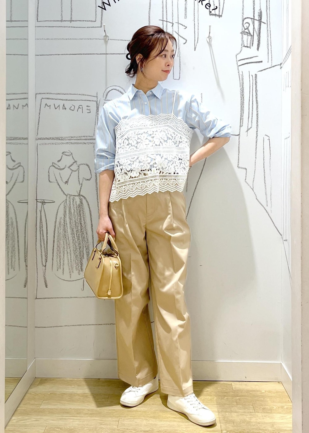 ベージュ系のボストンバッグ、ベージュ系のチノパンツ、ブルー系のシャツ/ブラウスを着用したレディースの春コーディネートの2枚目の写真