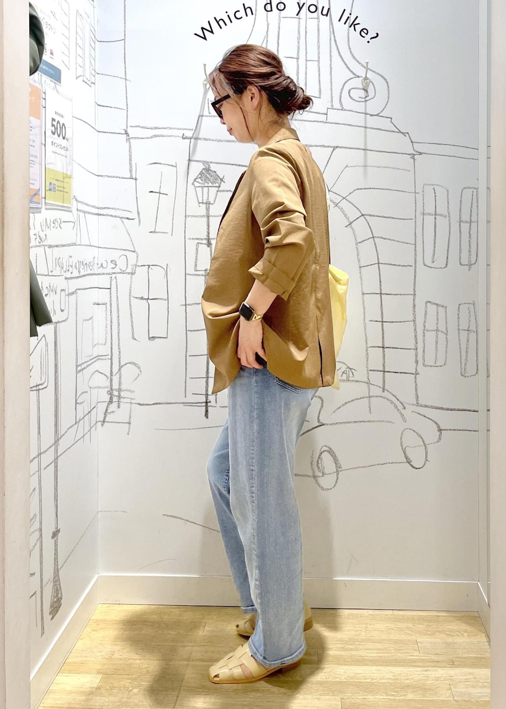 ブルー系のデニムパンツ、ベージュ系のサンダル、イエロー系のテーラードジャケットを着用したレディースの春コーディネートの4枚目の写真
