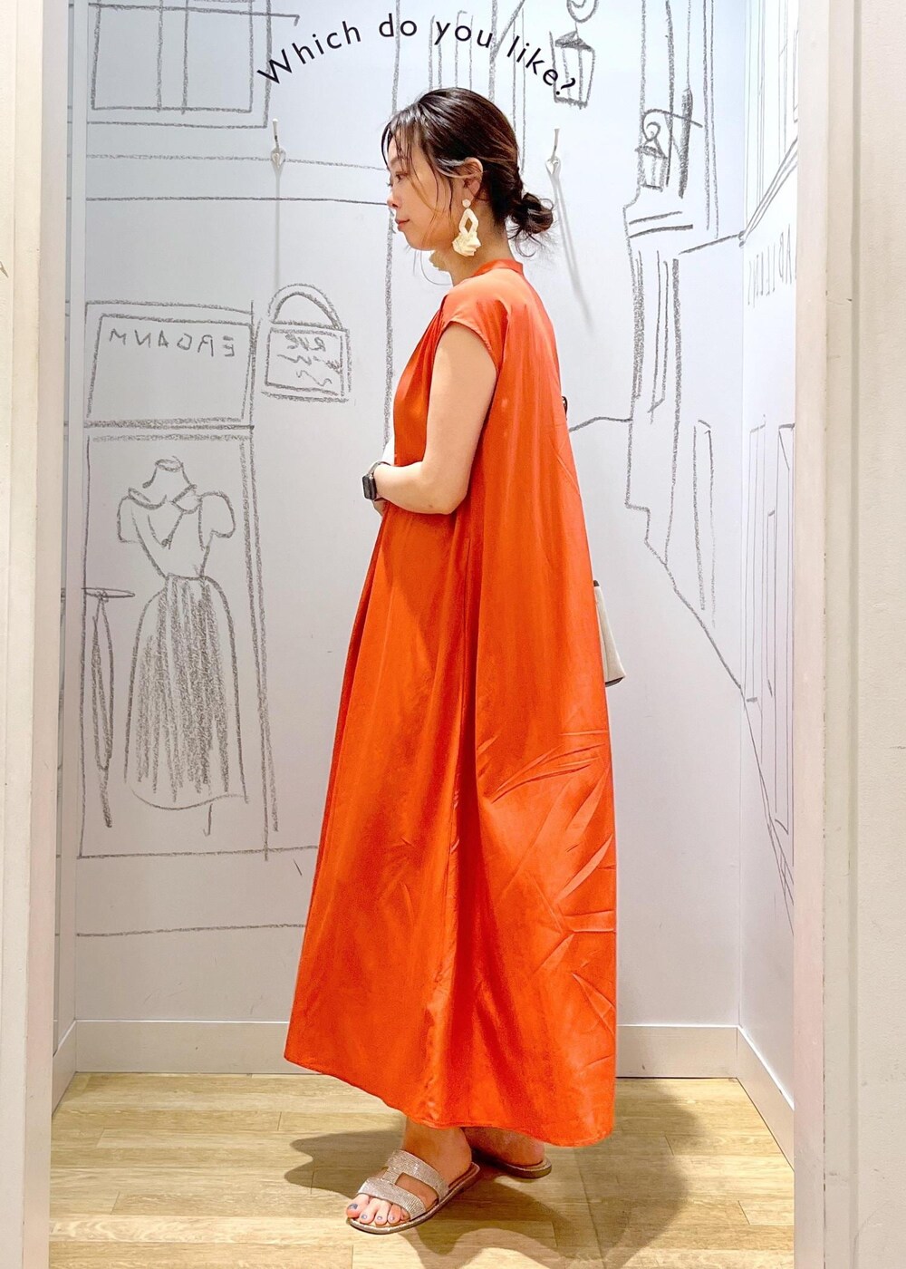 ブラウン系のトートバッグ、オレンジ系のワンピースを着用したレディースの夏コーディネートの4枚目の写真
