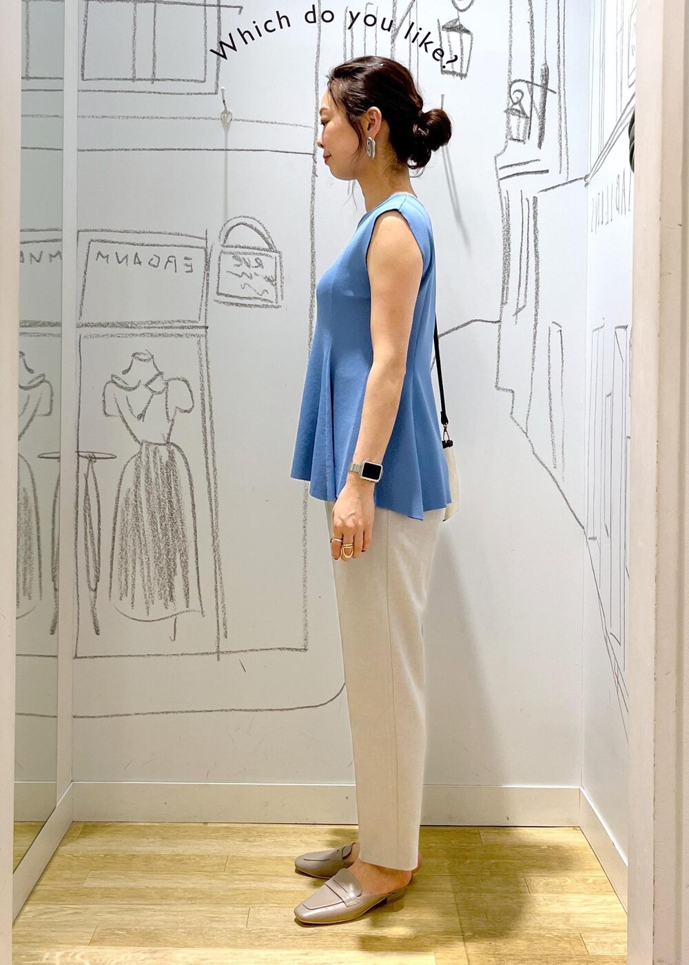 ブルー系のニット/セーター、ブラック系のトートバッグ、グレー系のスラックスを着用したレディースの夏コーディネートの4枚目の写真