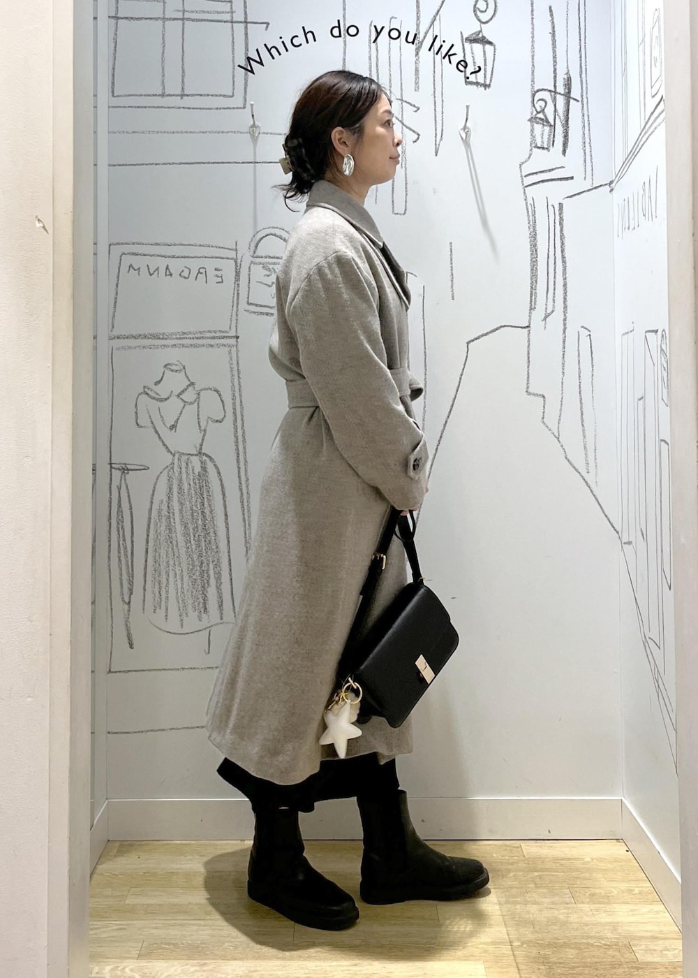 ブラック系のショルダーバッグ、ブラック系のスカート、ベージュ系のチェスターコートを着用したレディースの冬コーディネートの3枚目の写真