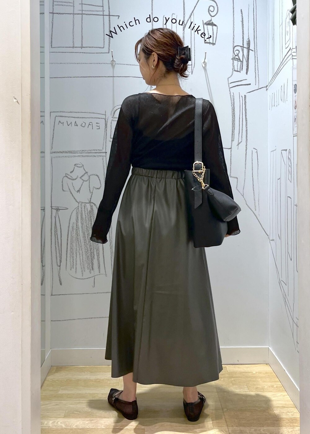 ブラック系のTシャツ/カットソー、ブラック系のショルダーバッグ、グリーン系のスカートを着用したレディースの秋コーディネートの5枚目の写真