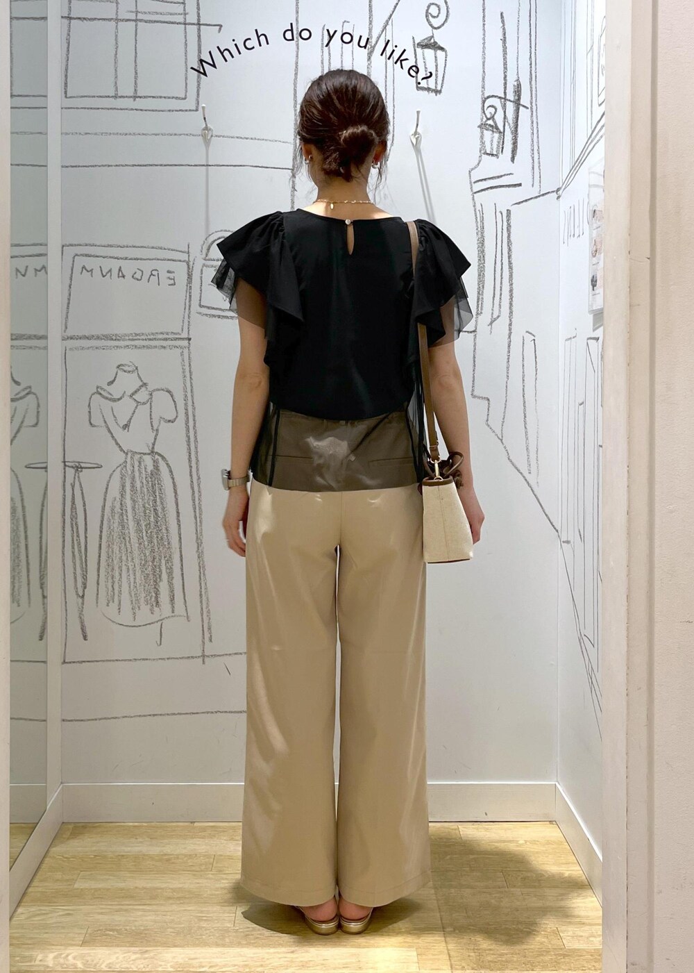 ベージュ系のチノパンツ、ブラウン系のトートバッグ、ブラック系のTシャツ/カットソーを着用したレディースの春コーディネートの7枚目の写真