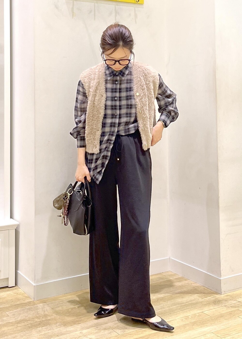 ブラック系のその他パンツ、ブラック系のトートバッグ、ブラック系のシャツ/ブラウスを着用したレディースの秋コーディネートの2枚目の写真