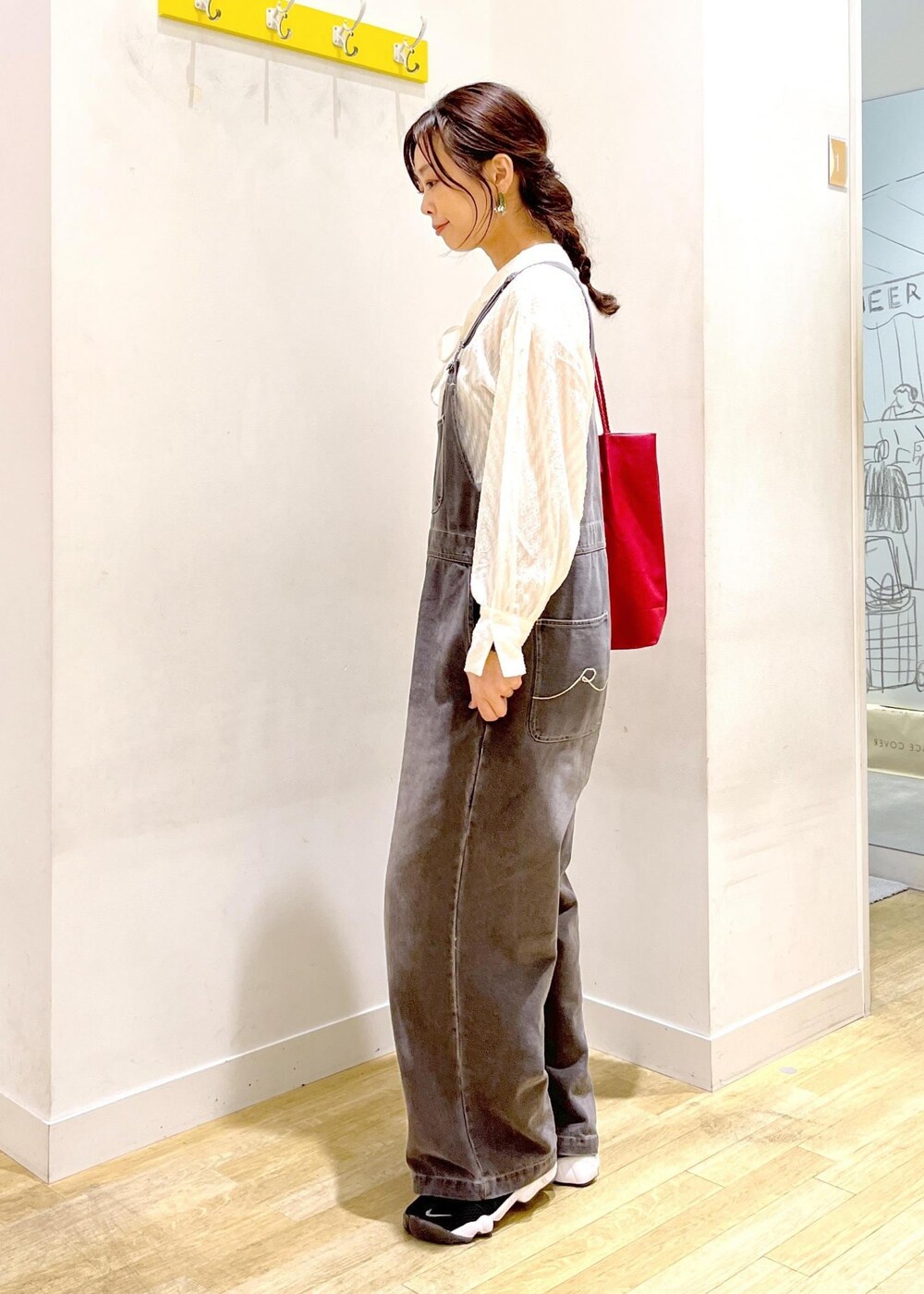 レッド系のトートバッグ、ホワイト系のシャツ/ブラウス、ブラック系のサロペット/オーバーオールを着用したレディースの秋コーディネートの4枚目の写真
