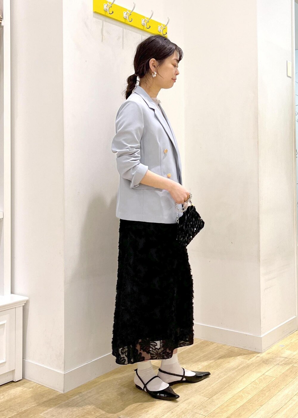 グレー系のシャツ/ブラウス、ブラック系のスカート、ブラック系のショルダーバッグを着用したレディースの春コーディネートの5枚目の写真