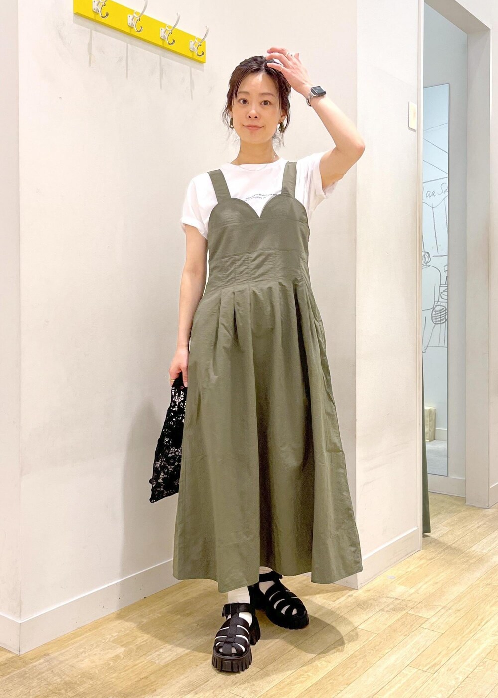 ブラック系のサンダル、グリーン系のワンピース、ブラック系のトートバッグを着用したレディースの春コーディネートの3枚目の写真