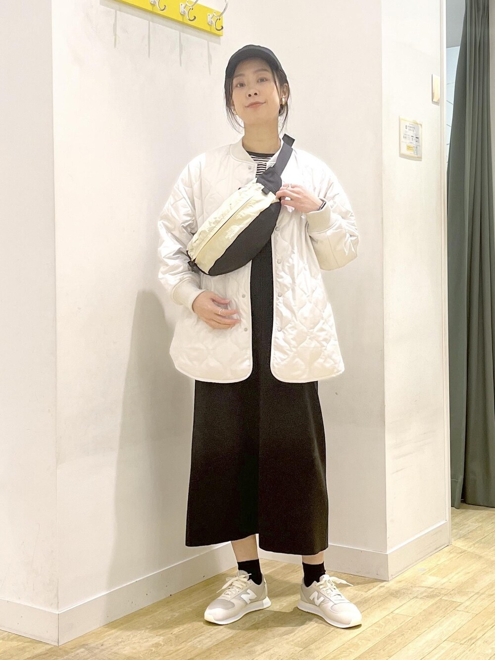 ブラック系のジャンパースカート、ブラック系のTシャツ/カットソー、ベージュ系のボディバッグ/ウエストポーチを着用したレディースの冬コーディネートの2枚目の写真