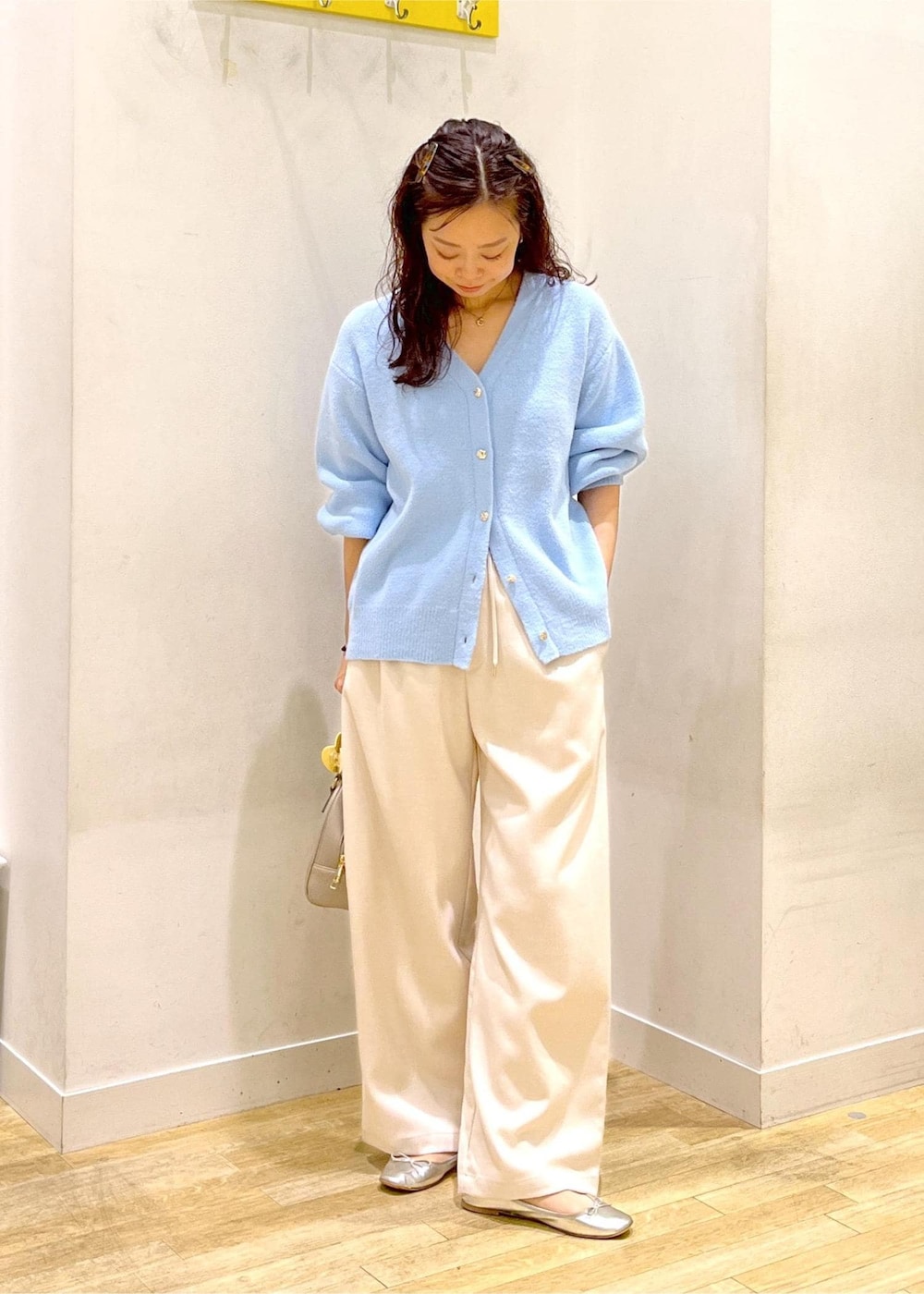 ホワイト系のその他パンツ、ブルー系のカーディガン/ボレロ、ベージュ系のボストンバッグを着用したレディースの秋コーディネートの2枚目の写真