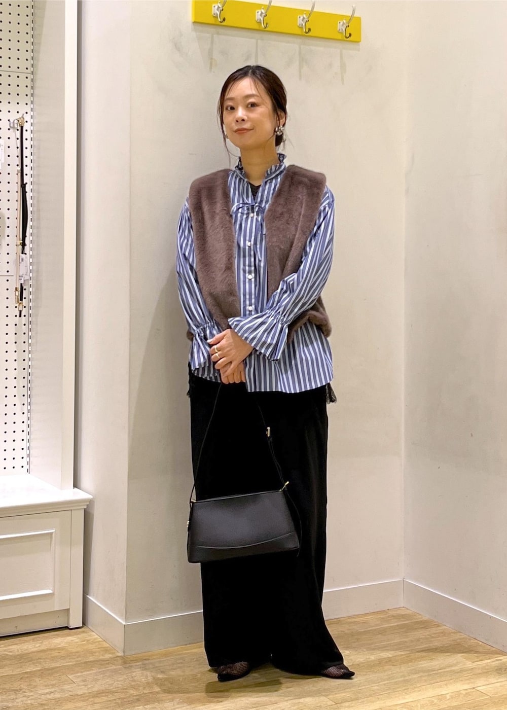 ブラック系のその他パンツ、ブラック系のショルダーバッグ、ブラウン系のベストを着用したレディースの秋コーディネートの4枚目の写真