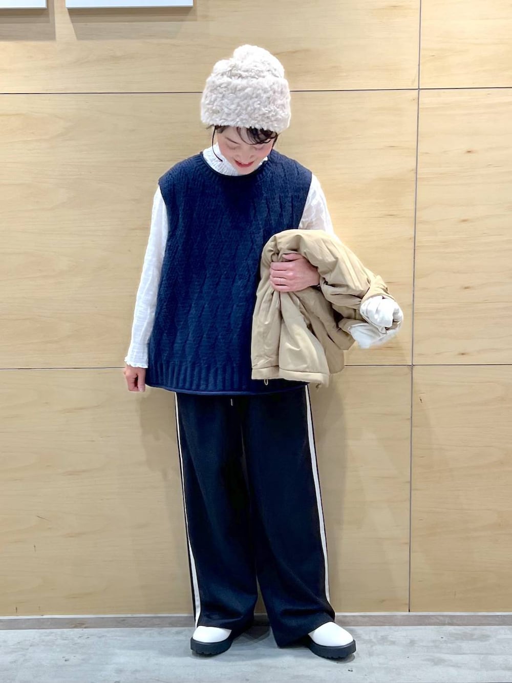 ベージュ系のブルゾン、ベージュ系のブーツ、ホワイト系のシャツ/ブラウスを着用したレディースの冬コーディネートの2枚目の写真