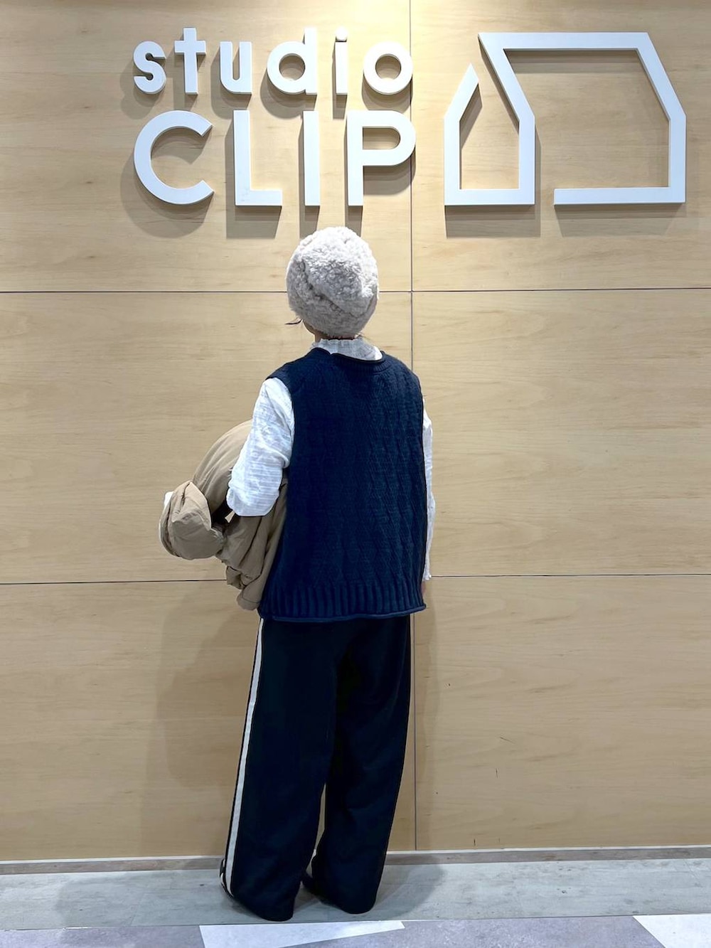 ベージュ系のブルゾン、ベージュ系のブーツ、ホワイト系のシャツ/ブラウスを着用したレディースの冬コーディネートの4枚目の写真