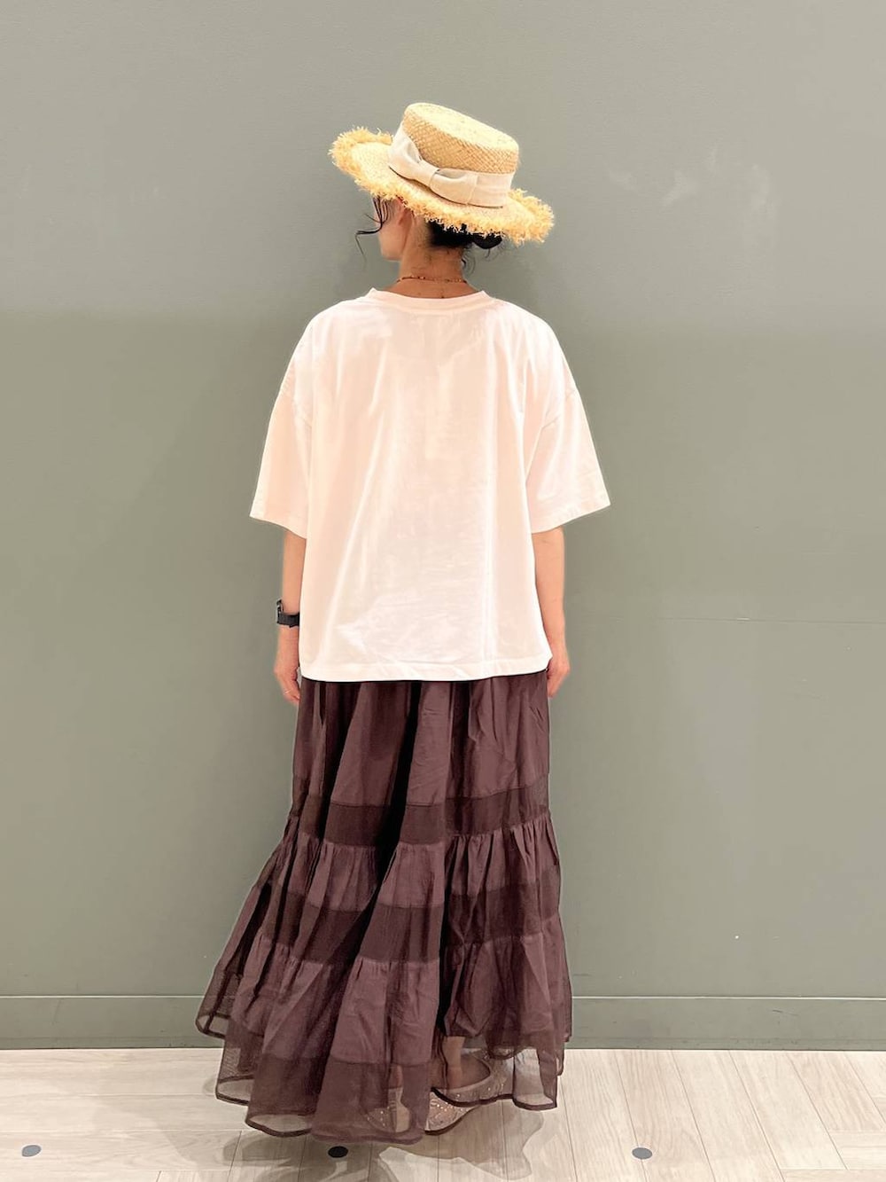 ブラック系のトートバッグ、ピンク系のTシャツ/カットソー、ブラウン系のスカートを着用したレディースの夏コーディネートの4枚目の写真