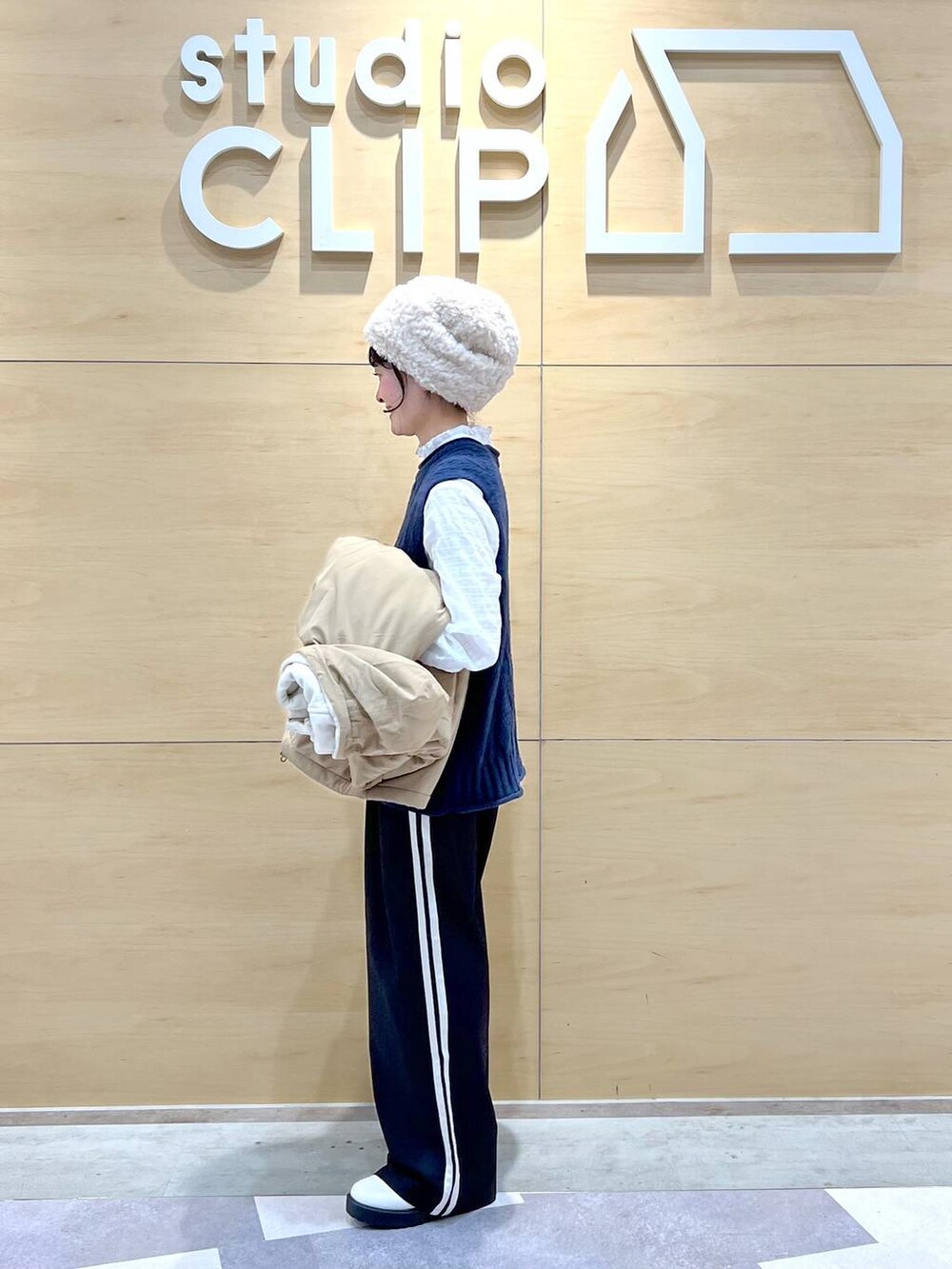 ベージュ系のブルゾン、ベージュ系のブーツ、ホワイト系のシャツ/ブラウスを着用したレディースの冬コーディネートの3枚目の写真