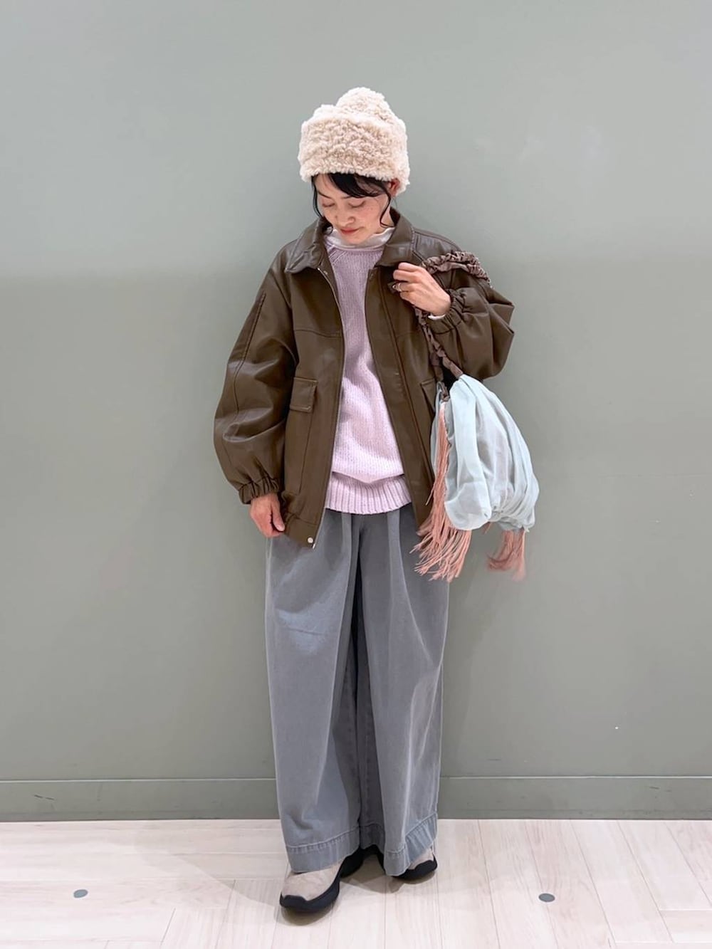 グレー系のブーツ、グリーン系のトートバッグ、グレー系のデニムパンツを着用したレディースの春コーディネートの2枚目の写真