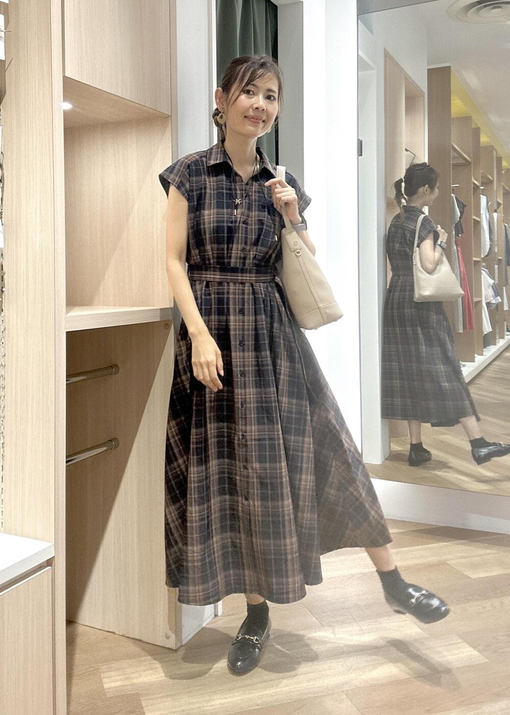 ブルー系のワンピース、ブラック系のローファー、ベージュ系のショルダーバッグを着用したレディースの夏コーディネートの6枚目の写真