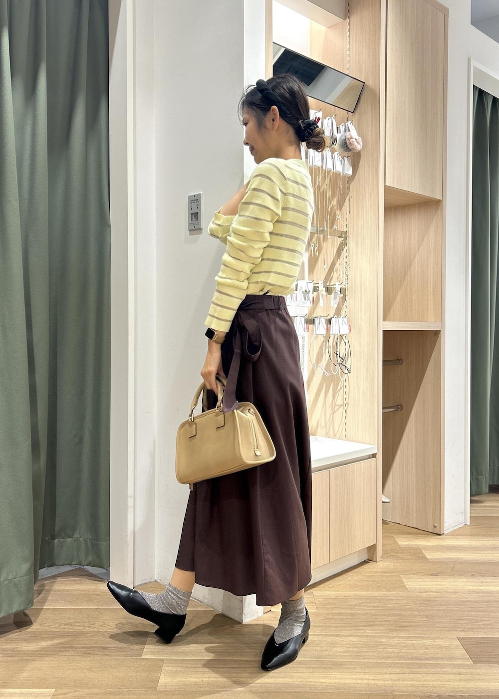 ベージュ系のボストンバッグ、ベージュ系のカーディガン/ボレロ、ブラック系のパンプスを着用したレディースの春コーディネートの3枚目の写真