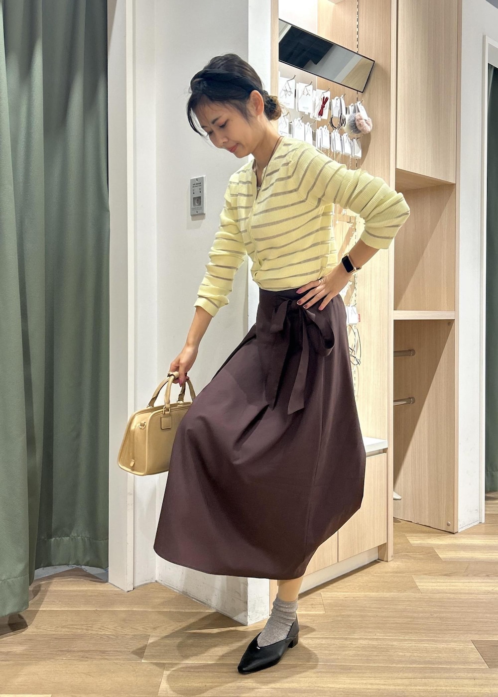 ベージュ系のボストンバッグ、ベージュ系のカーディガン/ボレロ、ブラック系のパンプスを着用したレディースの春コーディネートの8枚目の写真