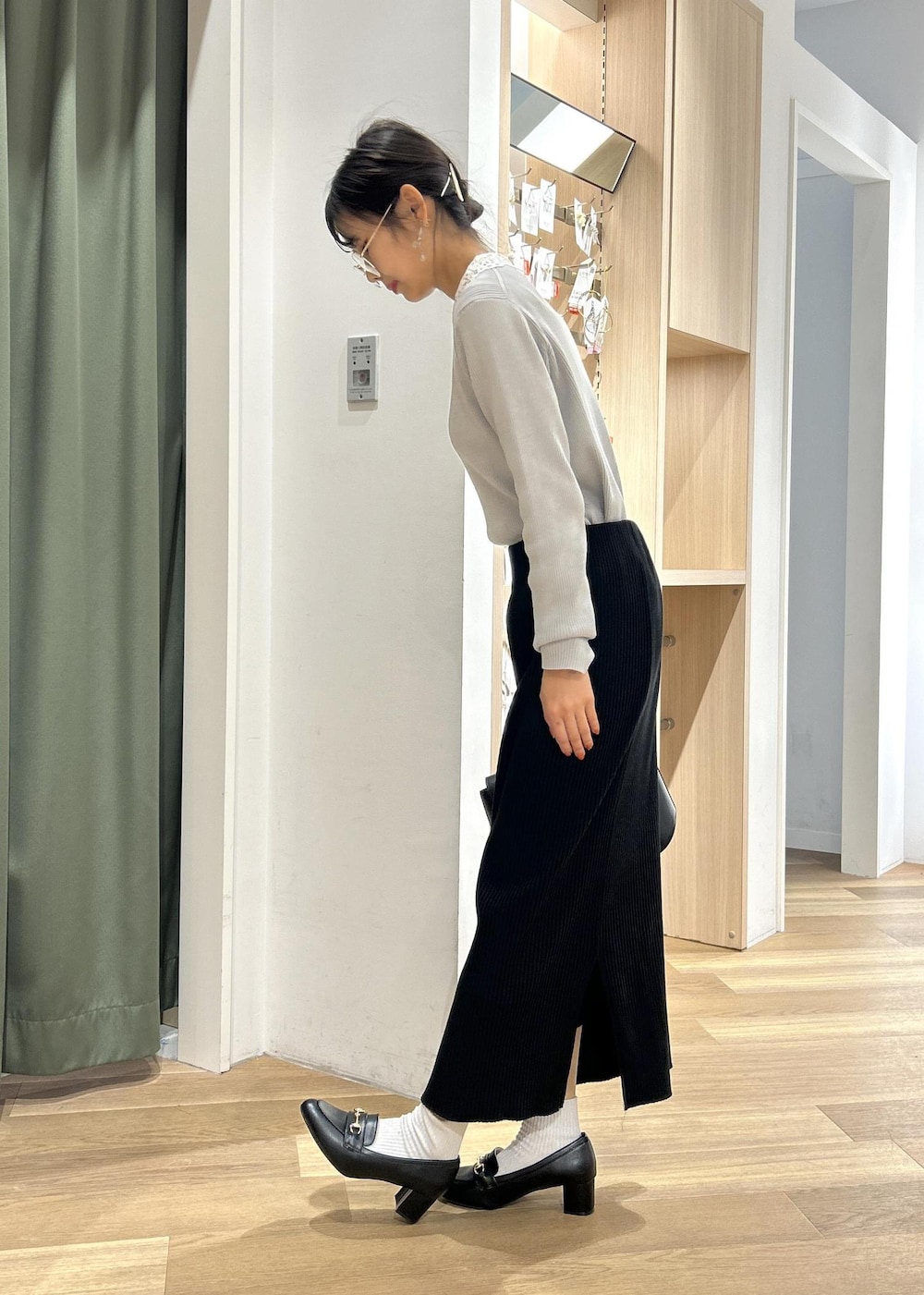 ブラック系のローファー、ブラック系のショルダーバッグ、グレー系のニット/セーターを着用したレディースの冬コーディネートの5枚目の写真