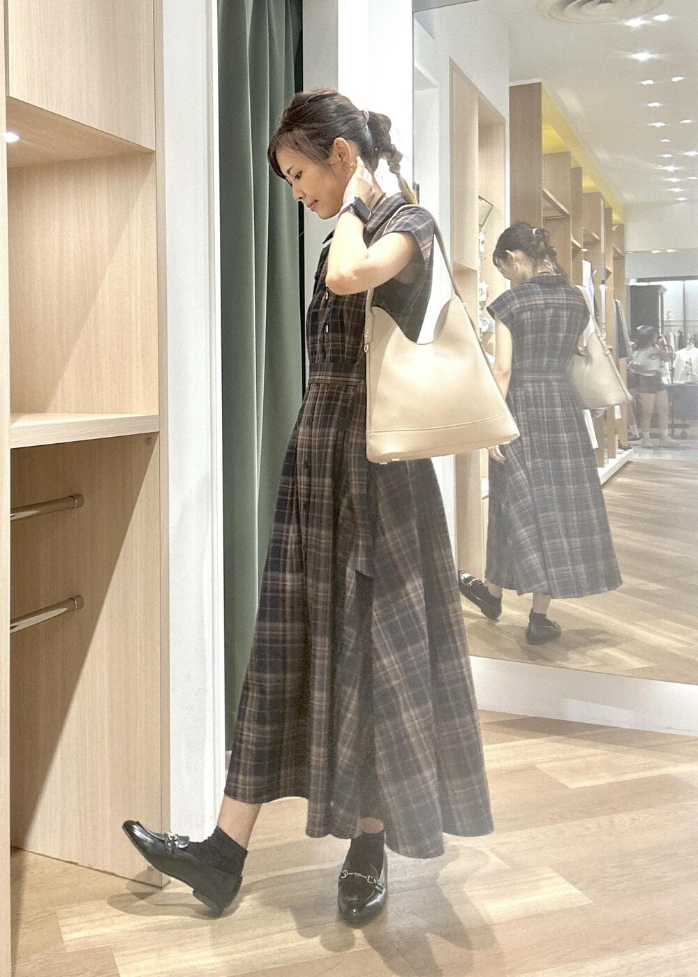 ブルー系のワンピース、ブラック系のローファー、ベージュ系のショルダーバッグを着用したレディースの夏コーディネートの2枚目の写真