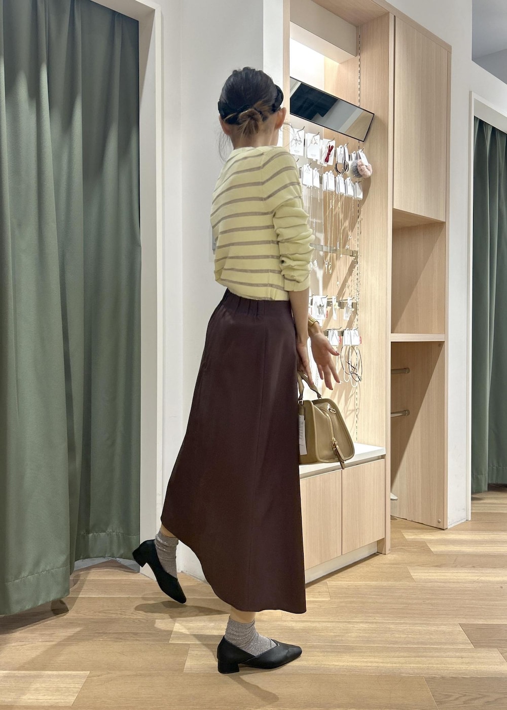 ベージュ系のボストンバッグ、ベージュ系のカーディガン/ボレロ、ブラック系のパンプスを着用したレディースの春コーディネートの5枚目の写真