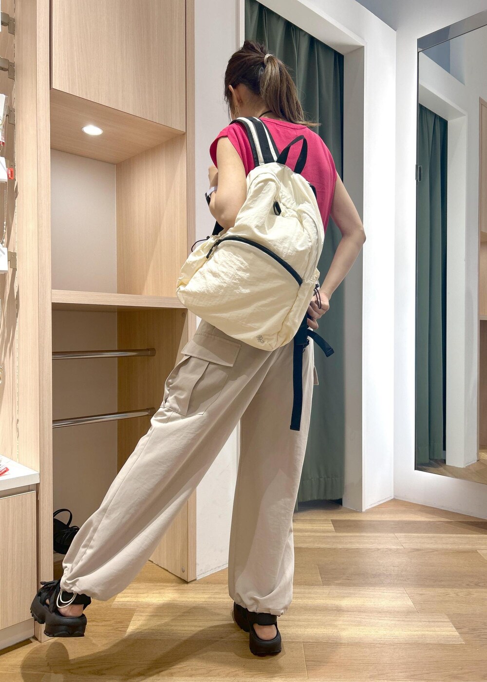 ピンク系のニット/セーター、ベージュ系のカーゴパンツ、ブラック系のサンダルを着用したレディースの夏コーディネートの4枚目の写真