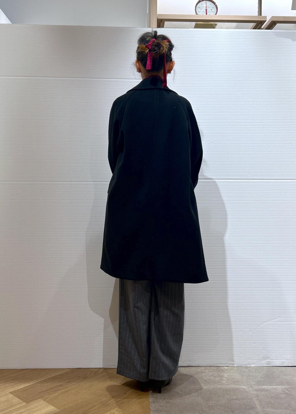 レッド系のニット/セーター、ブラック系のブーツ、グレー系のトートバッグを着用したレディースの秋コーディネートの5枚目の写真