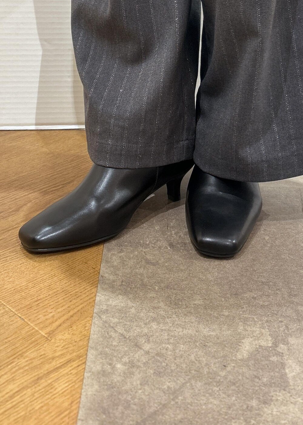 レッド系のニット/セーター、ブラック系のブーツ、グレー系のトートバッグを着用したレディースの秋コーディネートの9枚目の写真