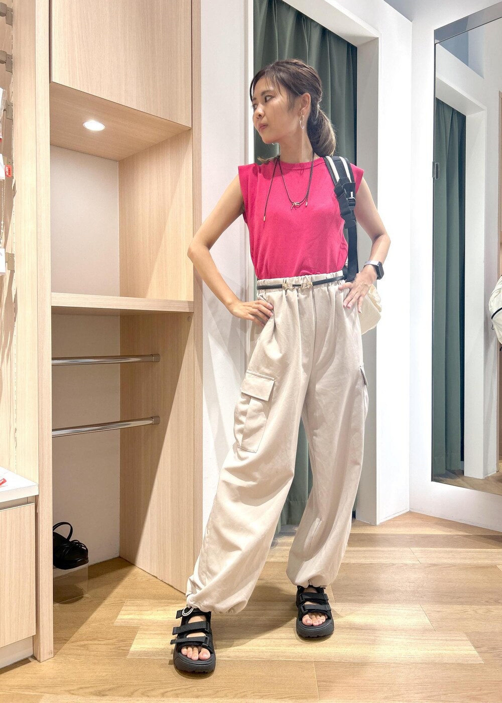 ピンク系のニット/セーター、ベージュ系のカーゴパンツ、ブラック系のサンダルを着用したレディースの夏コーディネートの5枚目の写真