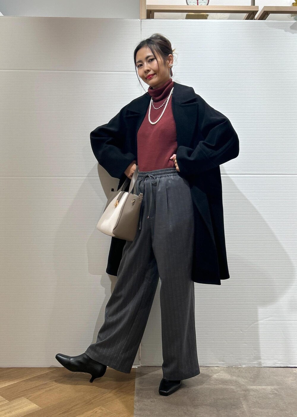 レッド系のニット/セーター、ブラック系のブーツ、グレー系のトートバッグを着用したレディースの秋コーディネートの7枚目の写真