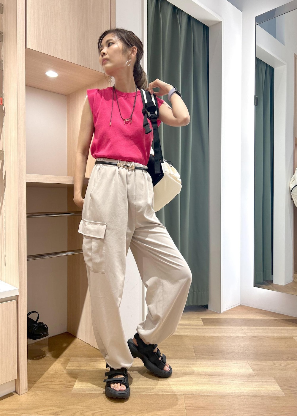ピンク系のニット/セーター、ベージュ系のカーゴパンツ、ブラック系のサンダルを着用したレディースの夏コーディネートの6枚目の写真