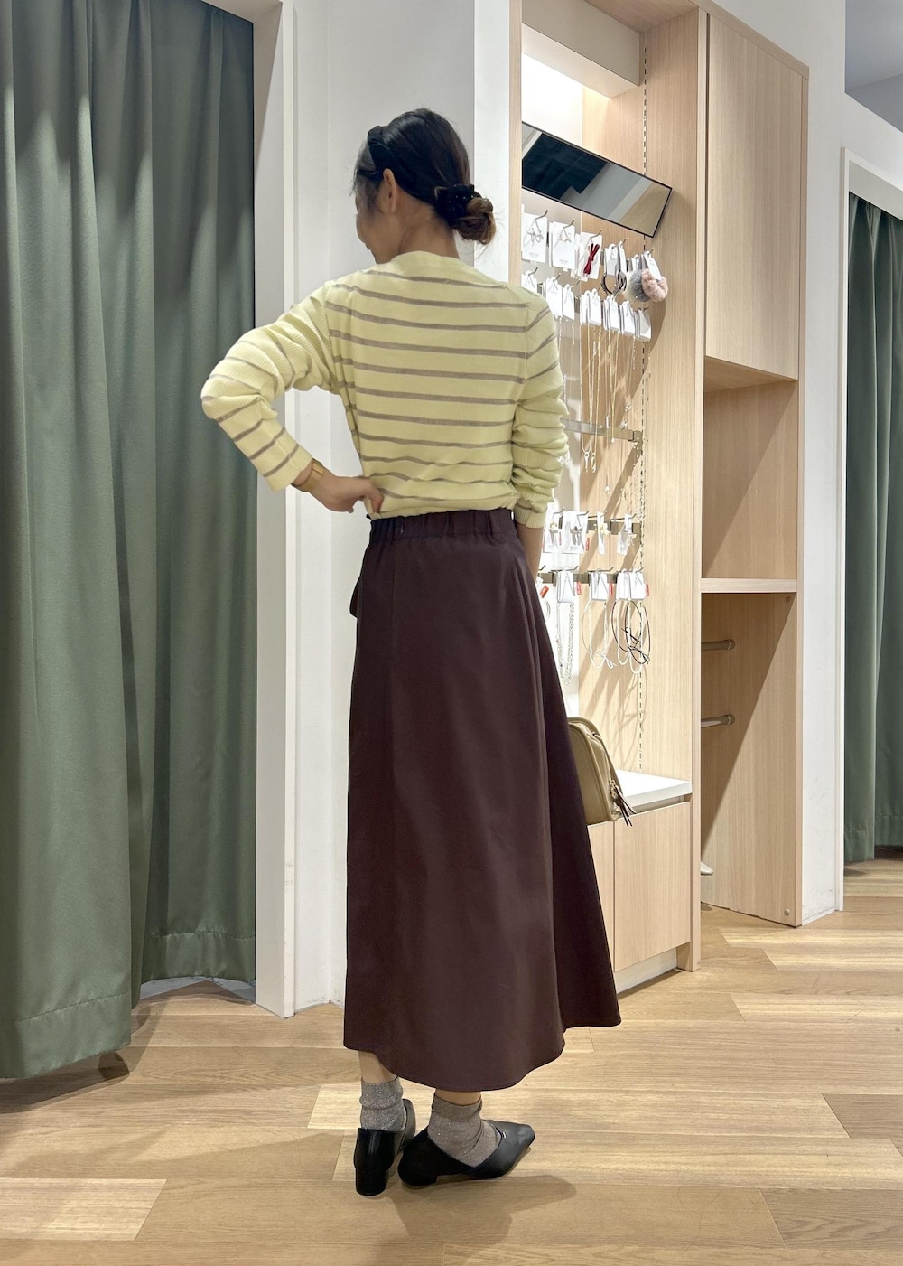 ベージュ系のボストンバッグ、ベージュ系のカーディガン/ボレロ、ブラック系のパンプスを着用したレディースの春コーディネートの4枚目の写真