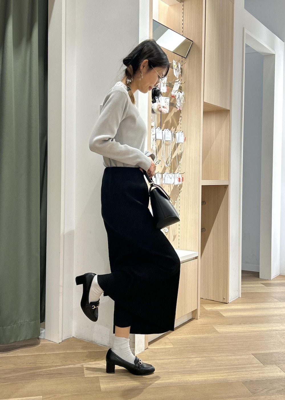 ブラック系のローファー、ブラック系のショルダーバッグ、グレー系のニット/セーターを着用したレディースの冬コーディネートの3枚目の写真