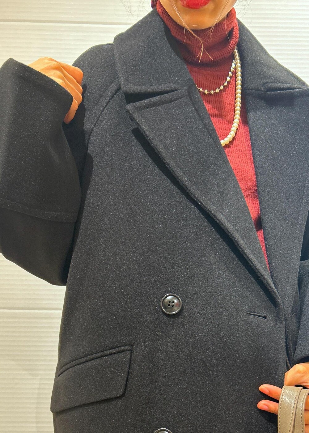 レッド系のニット/セーター、ブラック系のブーツ、グレー系のトートバッグを着用したレディースの秋コーディネートの10枚目の写真