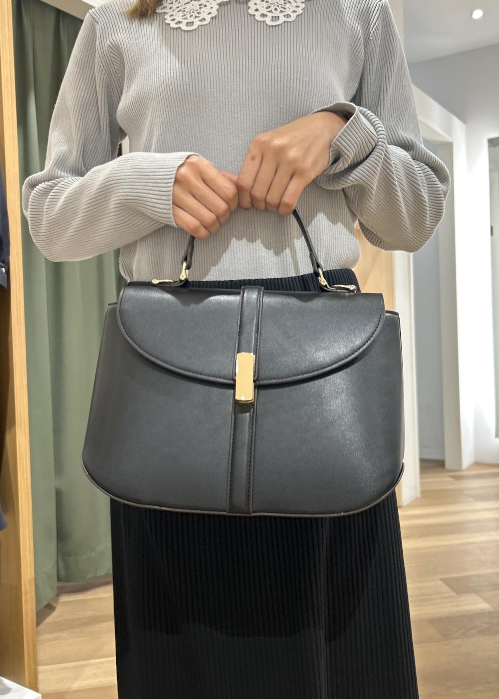 ブラック系のローファー、ブラック系のショルダーバッグ、グレー系のニット/セーターを着用したレディースの冬コーディネートの8枚目の写真