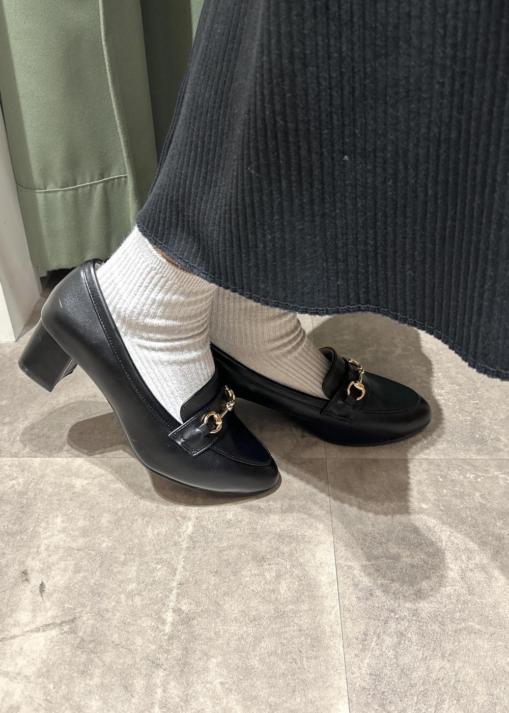 ブラック系のローファー、ブラック系のショルダーバッグ、グレー系のニット/セーターを着用したレディースの冬コーディネートの10枚目の写真