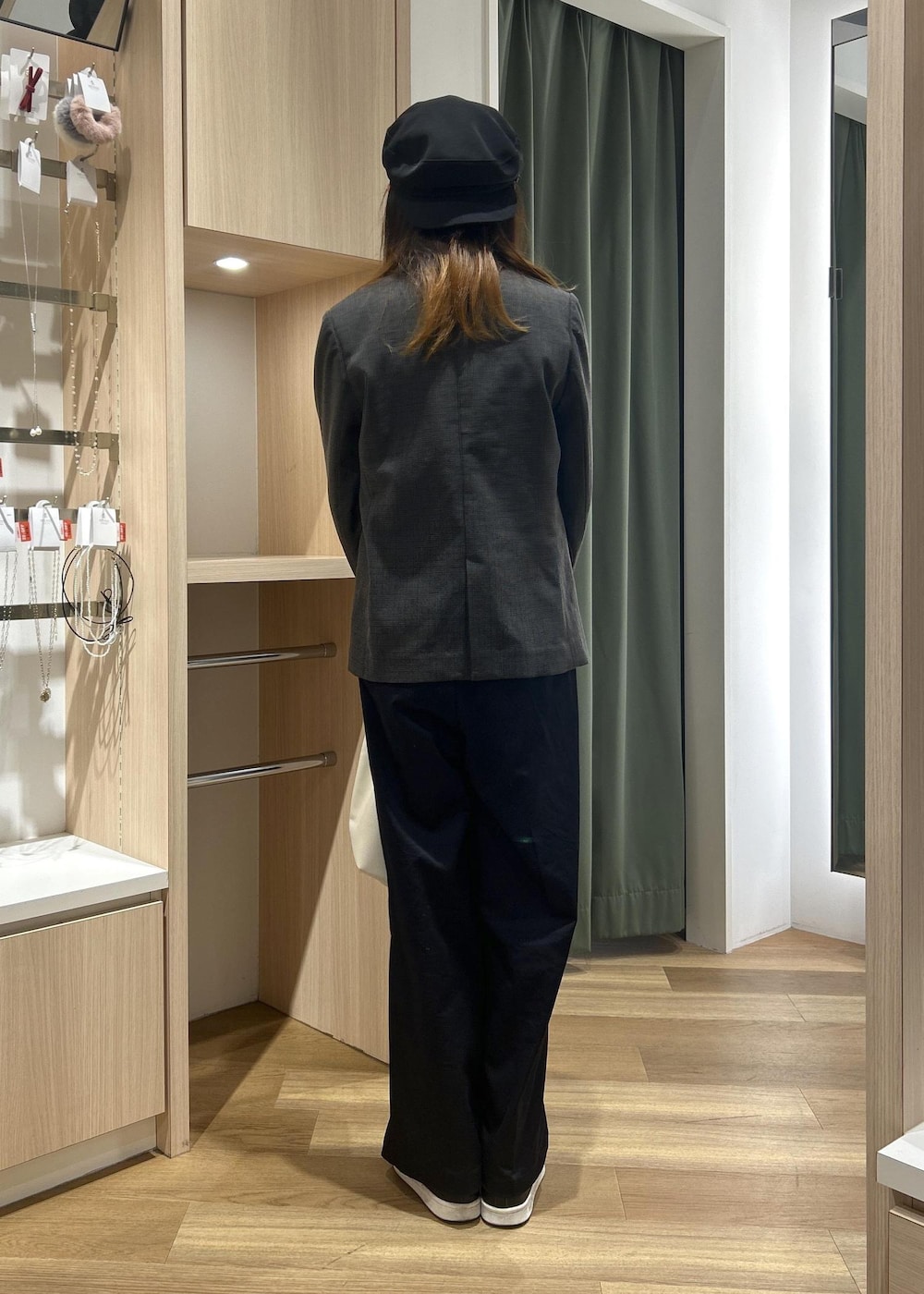 グレー系のテーラードジャケット、ホワイト系のトートバッグ、ブルー系のチノパンツを着用したレディースの冬コーディネートの7枚目の写真