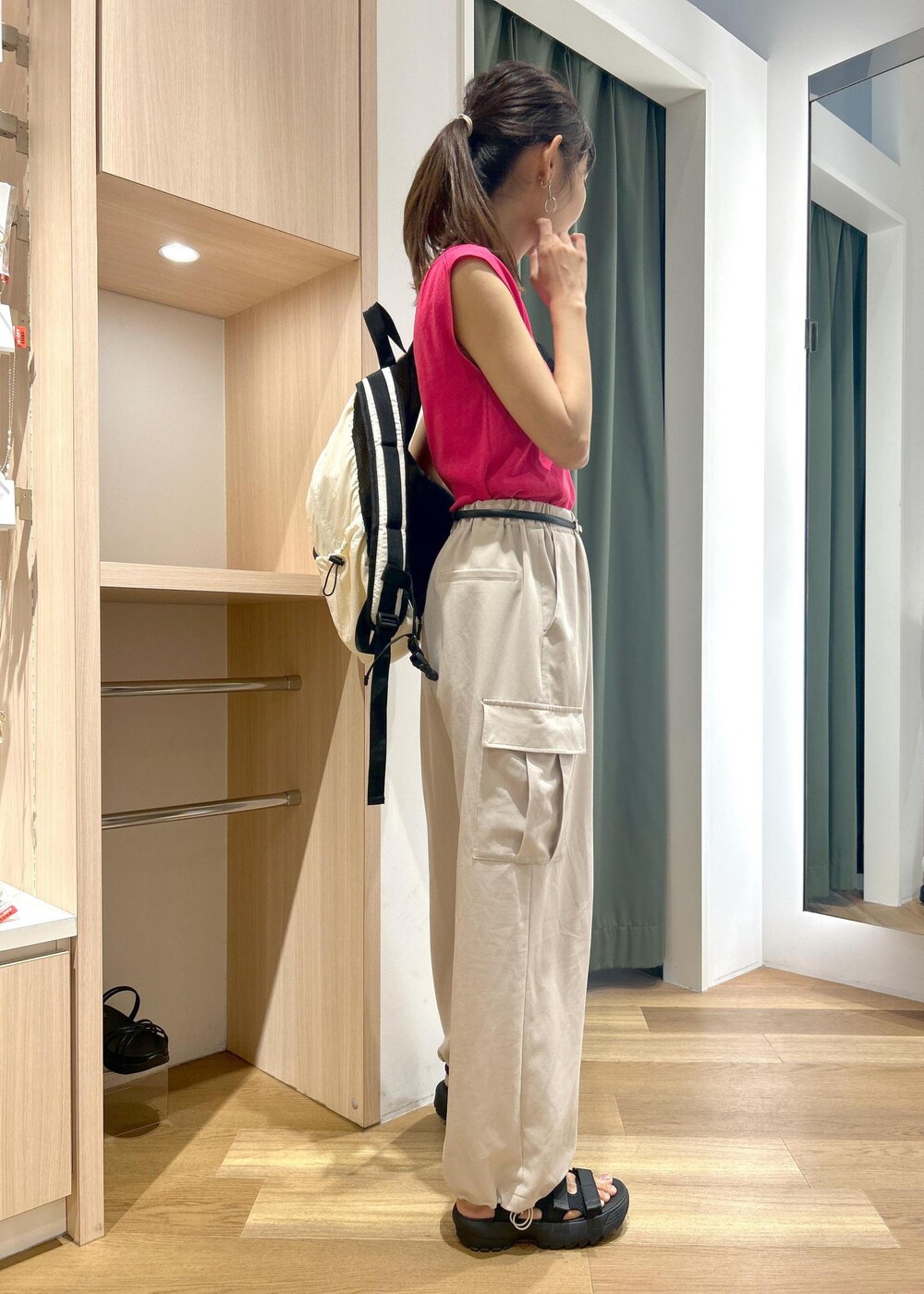 ピンク系のニット/セーター、ベージュ系のカーゴパンツ、ブラック系のサンダルを着用したレディースの夏コーディネートの2枚目の写真