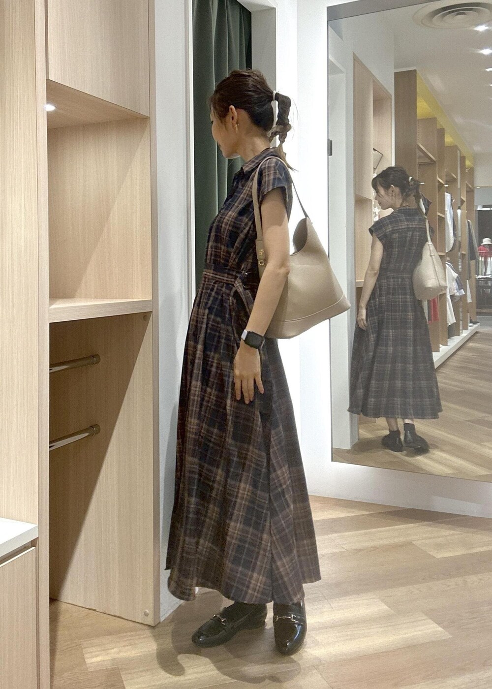 ブルー系のワンピース、ブラック系のローファー、ベージュ系のショルダーバッグを着用したレディースの夏コーディネートの3枚目の写真