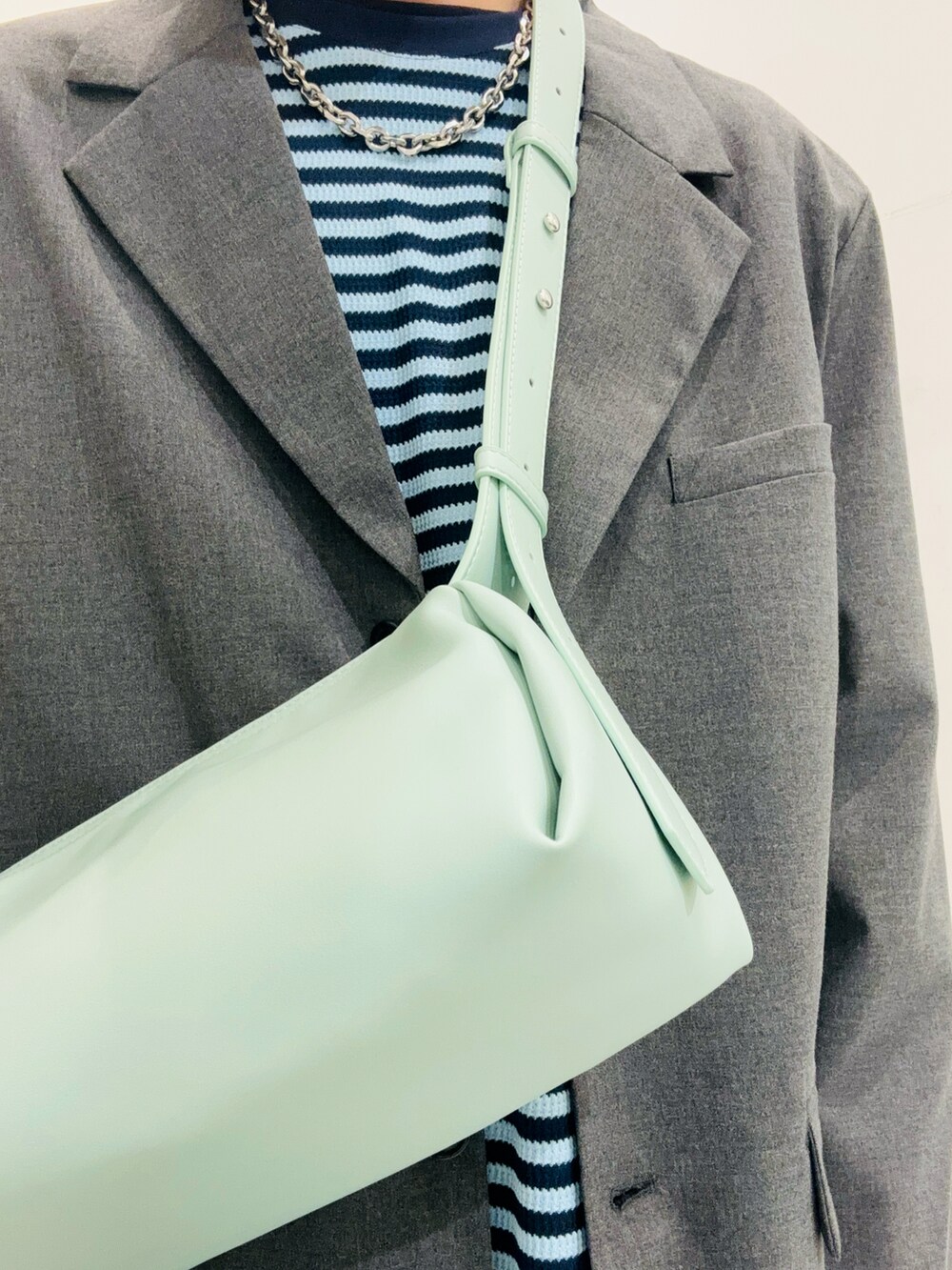 グレー系のその他アウター、ブルー系のTシャツ/カットソー、グリーン系のショルダーバッグを着用したメンズの冬コーディネートの2枚目の写真